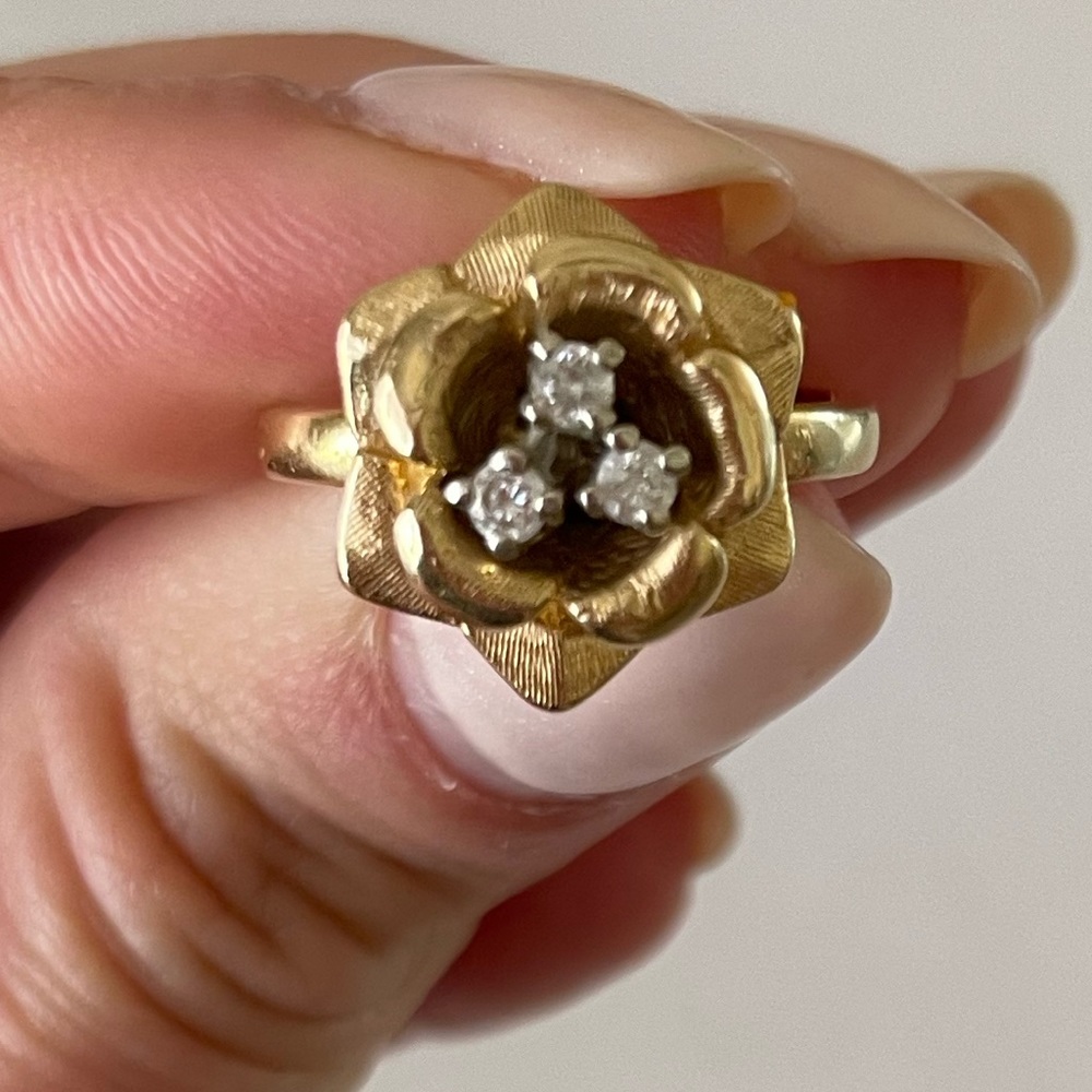 14 karat yellow gold ring w/a flower design w/set three 2mm round diamonds.